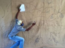 Keiskamma Art Project artist Siyabonga Maswana bringing the sacred fig tree to life on the hessian canvas of the COVID-19 Resilience Tapestry.